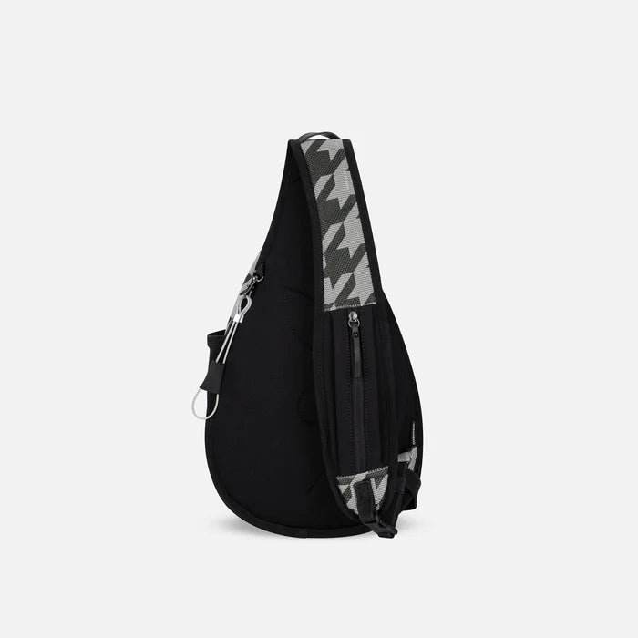 A Sherpani Esprit Houndstooth Anti-theft Sling Bag, back view showing the strap pocket and the chair lock on a white background. #color_houndstooth-print