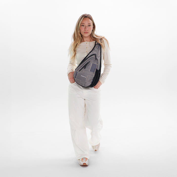 Woman wearing a Sherpani Esprit Passport Anti-theft Sling on her front against white backdrop. #color_passport-print