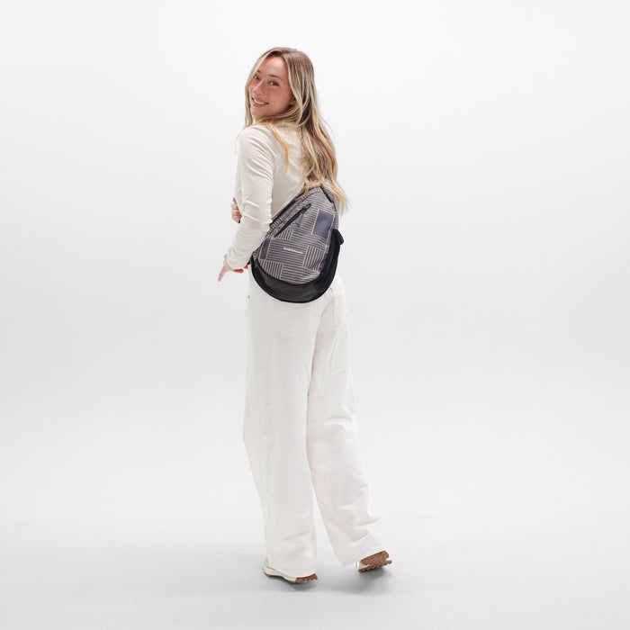 Woman wearing a Sherpani Esprit Passport Anti-theft Sling on her front against white backdrop. #color_passport-print