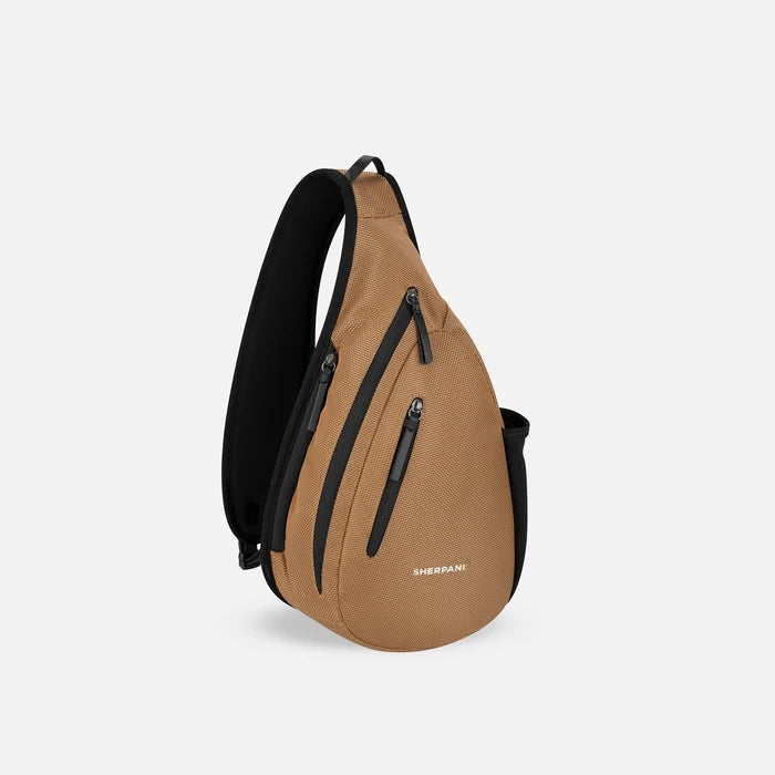 A Sherpani Esprit Sand Anti-theft Sling, 3/4 view showing strap & lockable pockets on white backdrop. #color_sand-tan