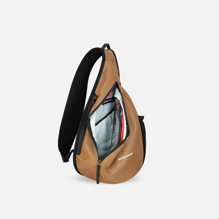 A Sherpani Esprit Sand Anti-theft Sling, side view showing inside main pocket on white backdrop. #color_sand-tan