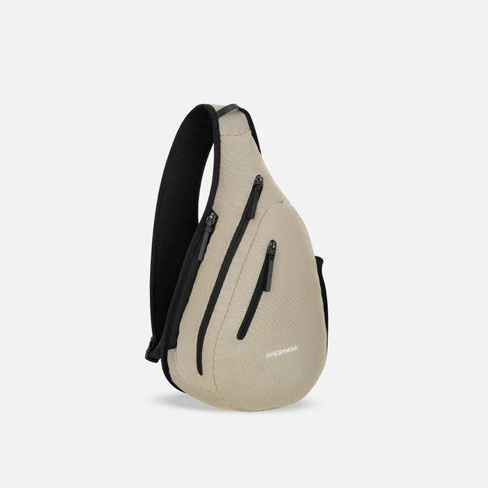 A Sherpani Esprit Straw Beige Anti-theft Sling Bag, 3/4 view showing lockable pockets and main strap on a white background. #color_straw-beige