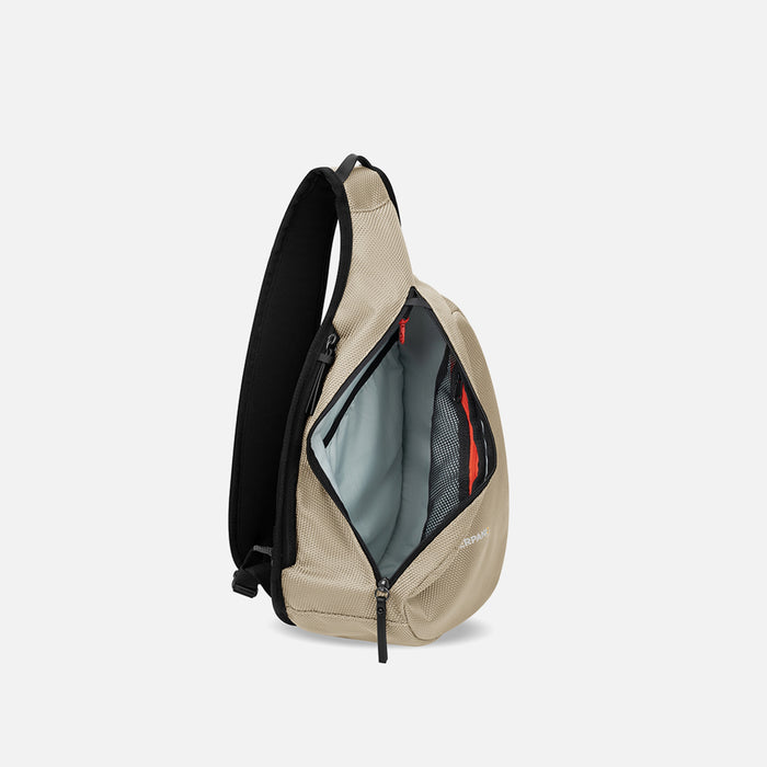 A Sherpani Esprit Straw Beige Anti-theft Sling Bag, side view showing inside main pocket on a white background. #color_straw-beige