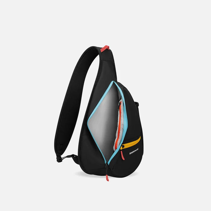 A Sherpani Esprit Chromatic Black Sling Bag, side view showing inside of main pocket with a sleeve on a white background. #color_chromatic-black