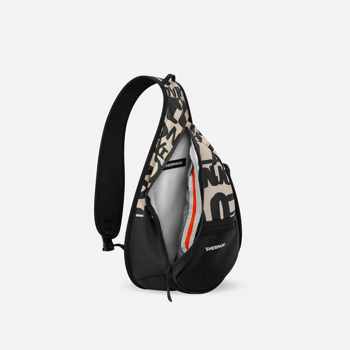 A Sherpani Esprit Ciao Sling Bag, side view showing inside of main pocket with a sleeve on a white background.  #color_ciao-print