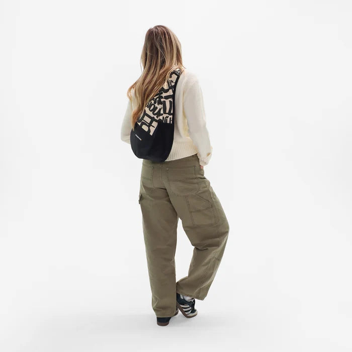 Woman wearing a Sherpani Esprit Ciao Sling on her back against white backdrop. #color_ciao-print