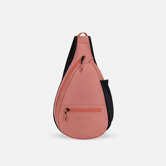 A Sherpani Esprit Desert Pink Sling, front view showing strap & lockable pockets on white backdrop.  #color_desert-pink