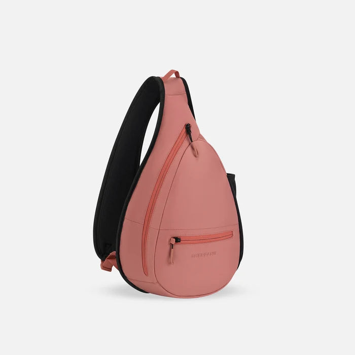 A Sherpani Esprit Desert Pink Sling, 3/4 view showing strap & lockable pockets on white backdrop. #color_desert-pink