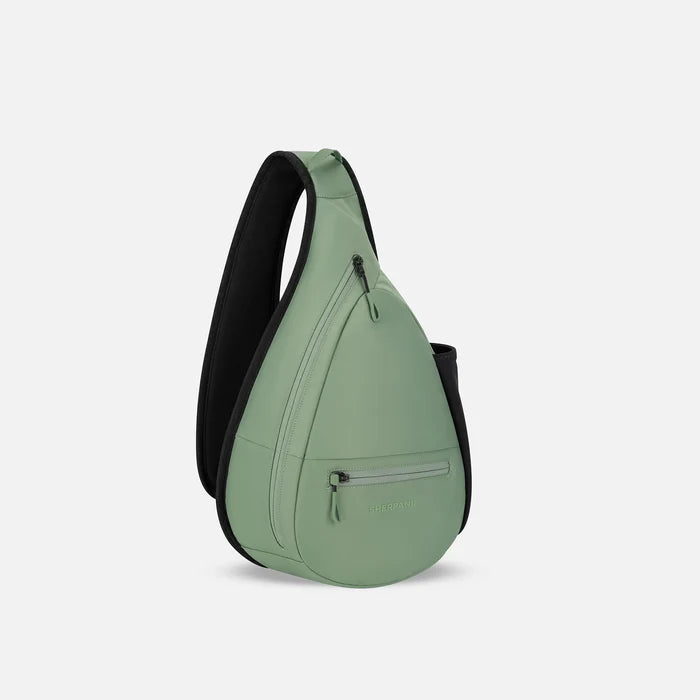 A Sherpani Esprit Olivine Sling, 3/4 view showing strap & lockable pockets on white backdrop.  #color_olivine-green