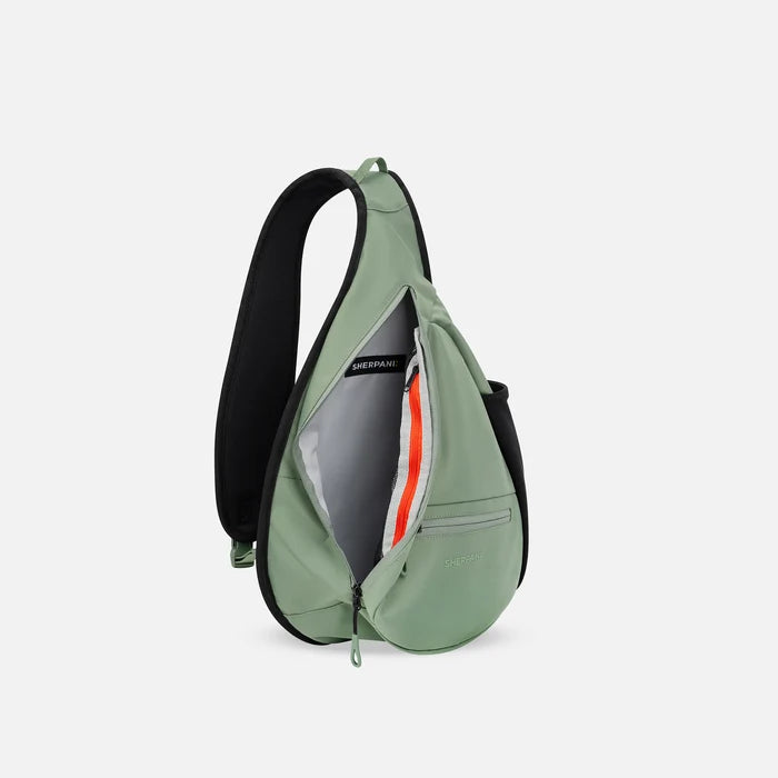 A Sherpani Esprit Olivine Sling Bag, side view showing inside of main pocket with a sleeve on a white background.  #color_olivine-green