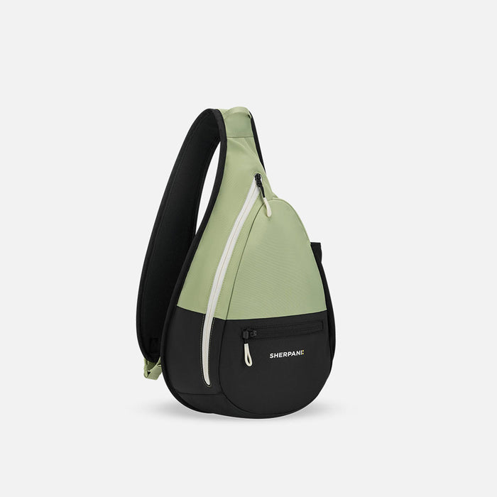 A Sherpani Esprit Palm Green Sling Bag, 3/4 view showing pockets and strap on white background.  #color_palm-green
