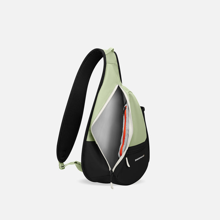 A Sherpani Esprit Palm Green Sling Bag, side view showing inside of main pocket with a sleeve on a white background.  #color_palm-green