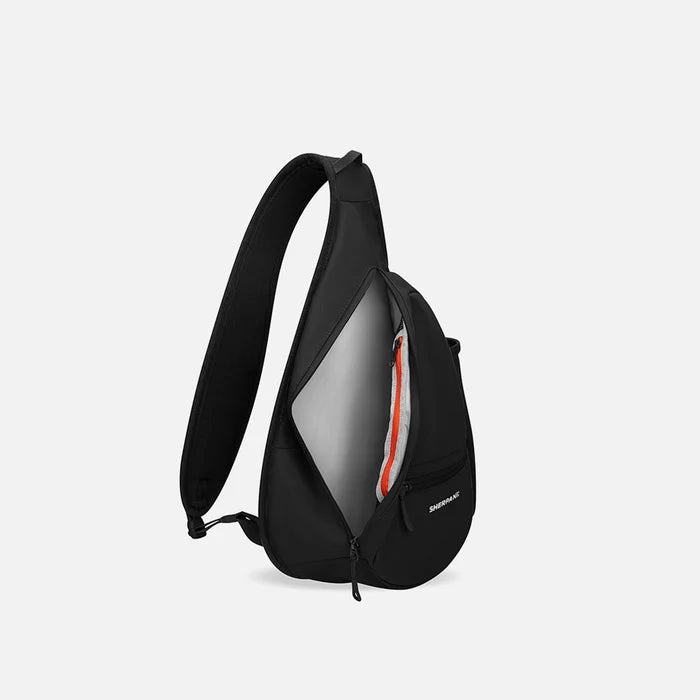 A Sherpani Esprit Raven Black Sling Bag, side view showing inside of main pocket with a sleeve on a white background.  #color_raven-black