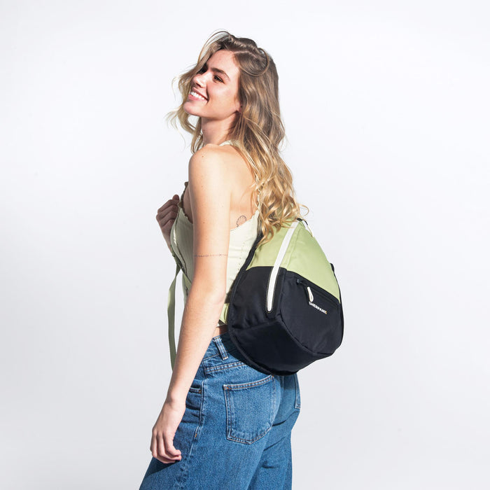 Woman wearing a Sherpani Esprit Palm Green Sling Bag against white background.  #color_palm-green