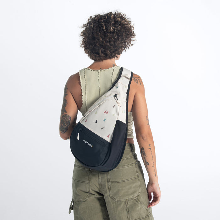 Woman wearing a Sherpani Esprit Terrazzo Print Sling Bag against white background.  #color_terrazzo-print