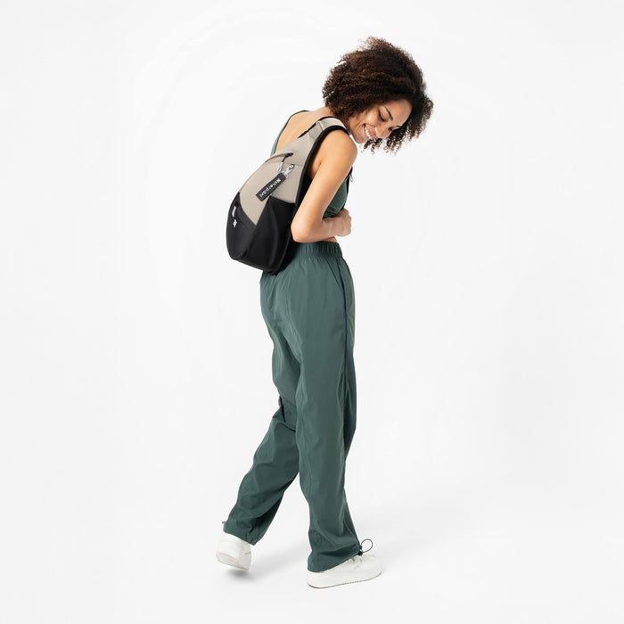 Woman wearing a Sherpani Esprit Con Leche Sling Bag against white background.  #color_con-leche-heritage