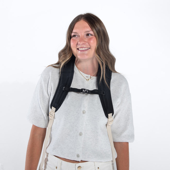 Woman a Sherpani Camden Terrazzo Print Backpack with shoulder straps buckled against white background. #color_terrazzo-print