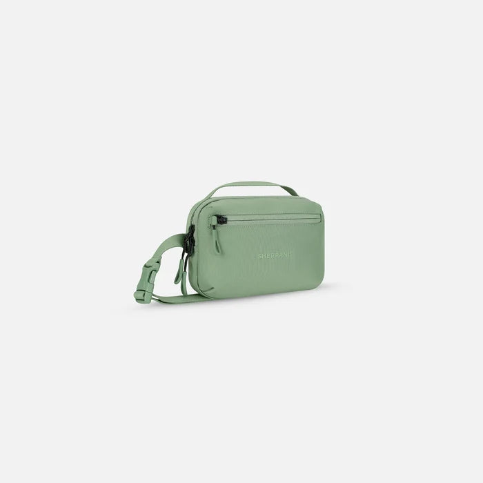 A Sherpani Hyk Olivine Hip Pack, 3/4 view showing pocket and straps on white backdrop. #color_olivine-green