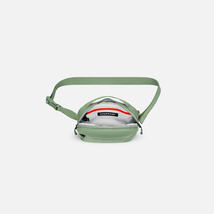 A Sherpani Hyk Olivine Hip Pack, above view showing inside of main pocket on white backdrop. #color_olivine-green
