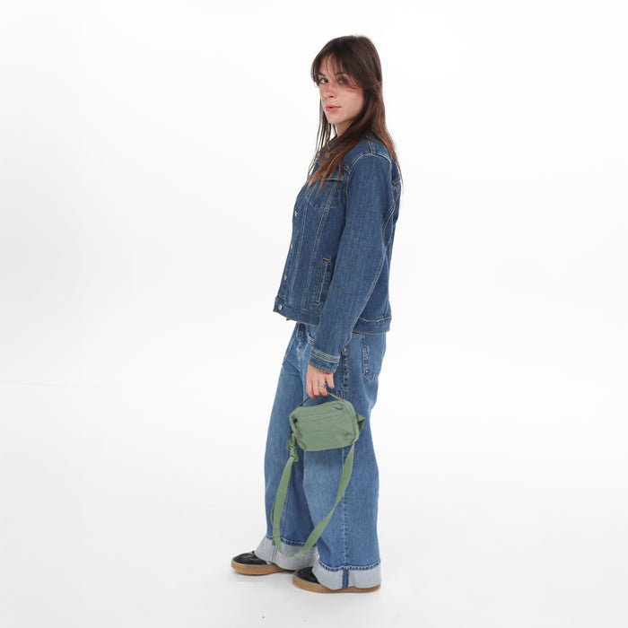 Woman holding a Sherpani Hyk Olivine Hip Pack against a white backdrop.   #color_olivine-green
