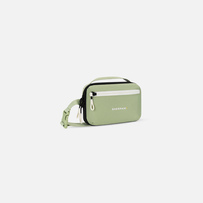 A Sherpani Hyk Palm Green Hip Pack, 3/4 view showing pocket and straps on white backdrop. #color_palm-green