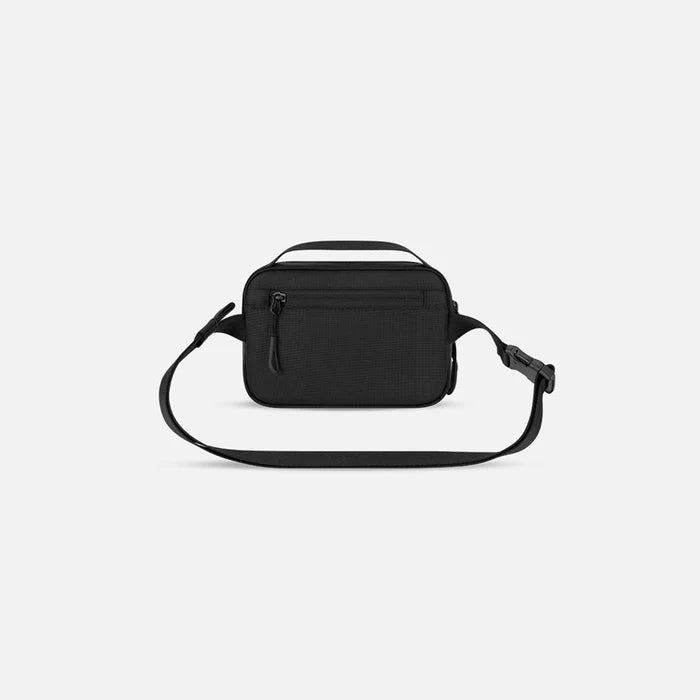 A Sherpani Hyk Raven Black Hip Pack, back view showing pocket and straps on white backdrop. #color_raven-black