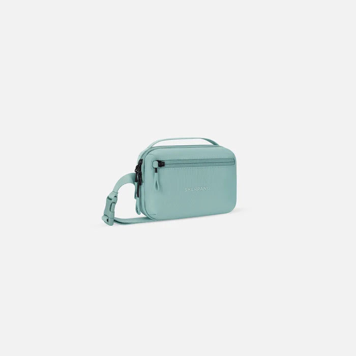 A Sherpani Hyk Surf Blue Hip Pack, 3/4 view showing pocket and straps on white backdrop. #color_surf-blue