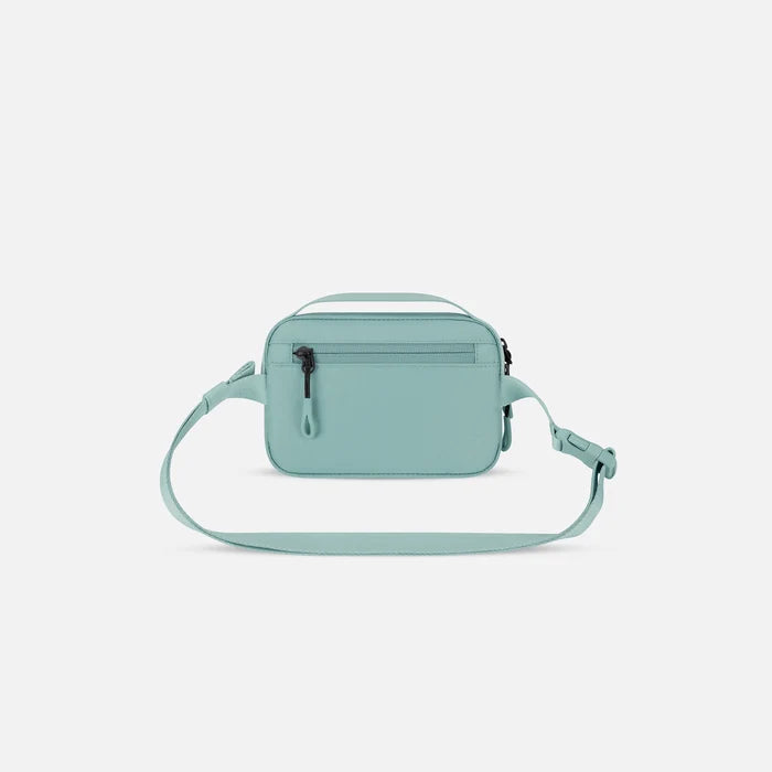 A Sherpani Hyk Surf Blue Hip Pack, back view showing pocket and straps on white backdrop. #color_surf-blue
