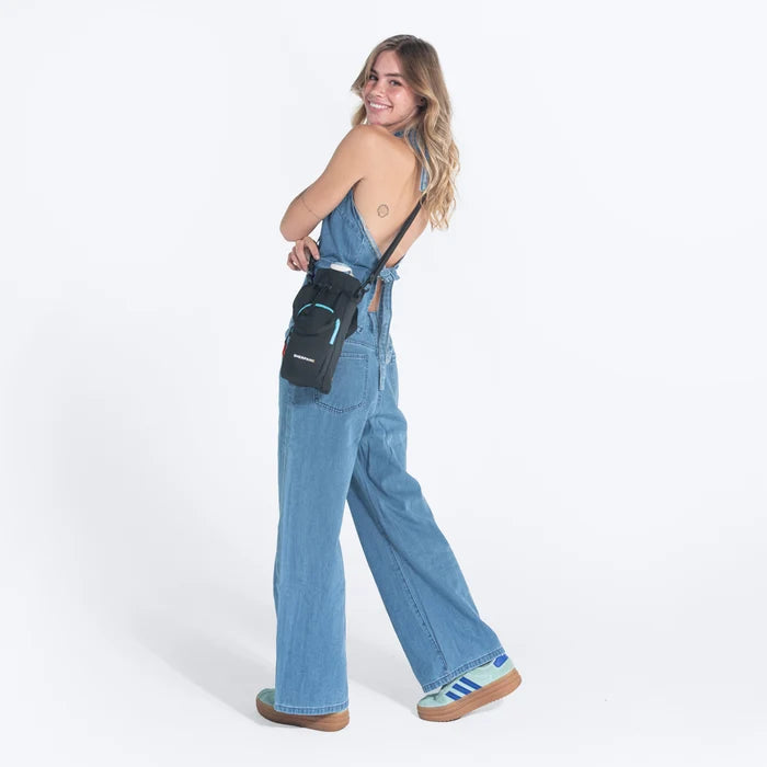 Woman wearing a Sherpani Izzie Chromatic Black Water Bottle Crossbody on white background.  # #color_chromatic-black