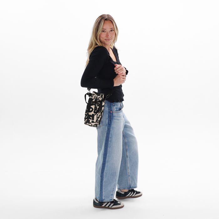 Woman wearing a Sherpani Izzie Ciao Water Bottle Crossbody on white background.  #color_ciao-print