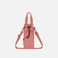 A Sherpani Izzie Desert Pink Water Bottle Crossbody, front view showing strap and front pocket on white background.  #color_desert-pink