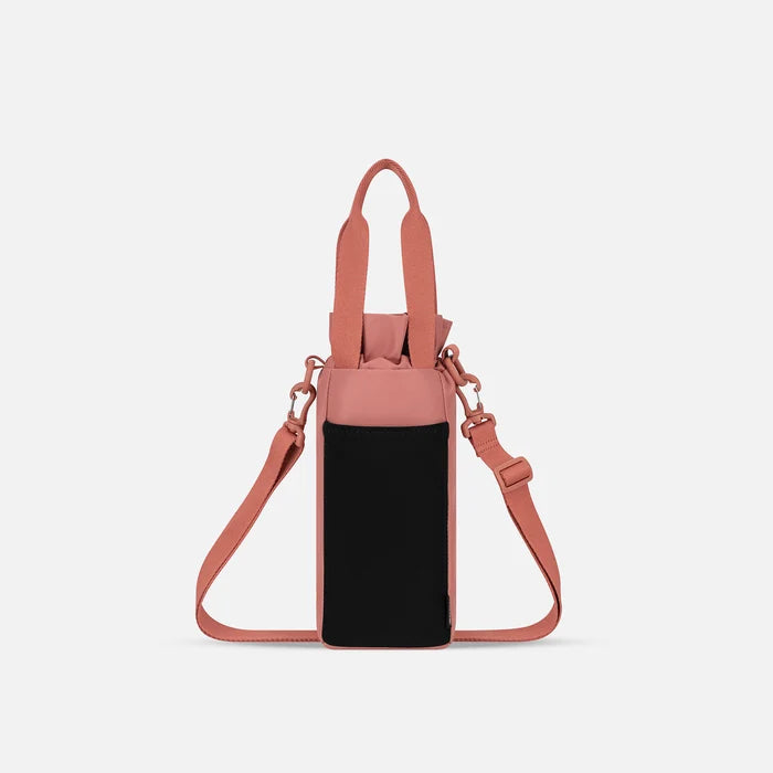 A Sherpani Izzie Desert Pink Water Bottle Crossbody, back view showing strap and back pocket on white background.  #color_desert-pink