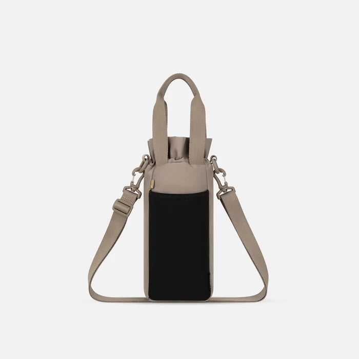 A Sherpani Izzie Dune Water Bottle Crossbody, back view showing strap and back pocket on white background.   #color_dune-tan