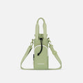 A Sherpani Izzie Palm Green Water Bottle Crossbody, front view showing strap and front pocket on white background.  #color_palm-green