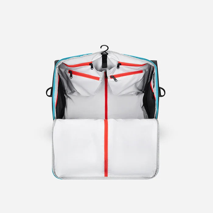 A Sherpani Jaunt Chromatic Black Garment Duffle, back view showing straps & luggage strap on white backdrop. #color_chromatic-black