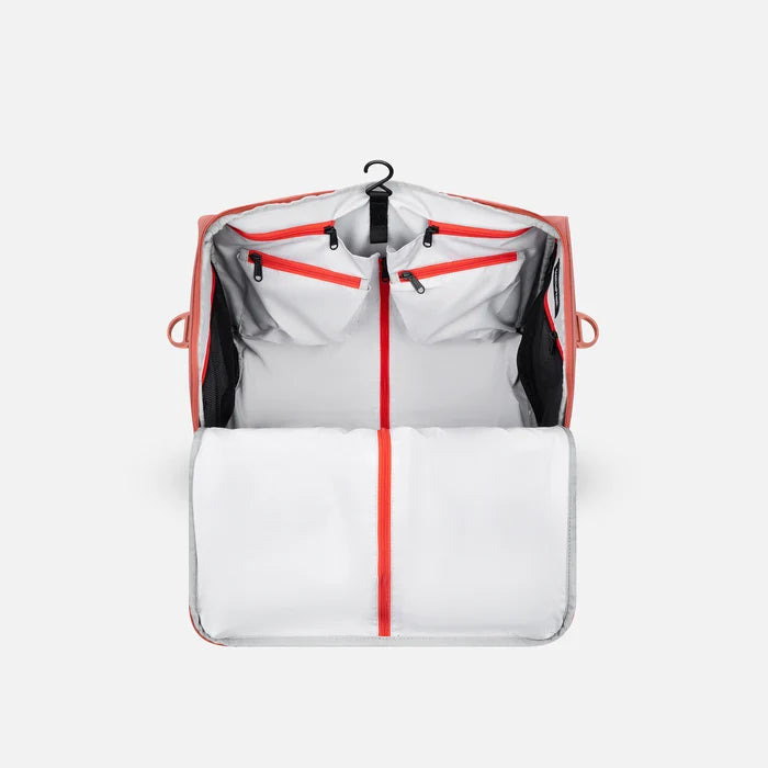 A Sherpani Jaunt Desert Pink Garment Duffle, back view showing straps & luggage strap on white backdrop. #color_desert-pink