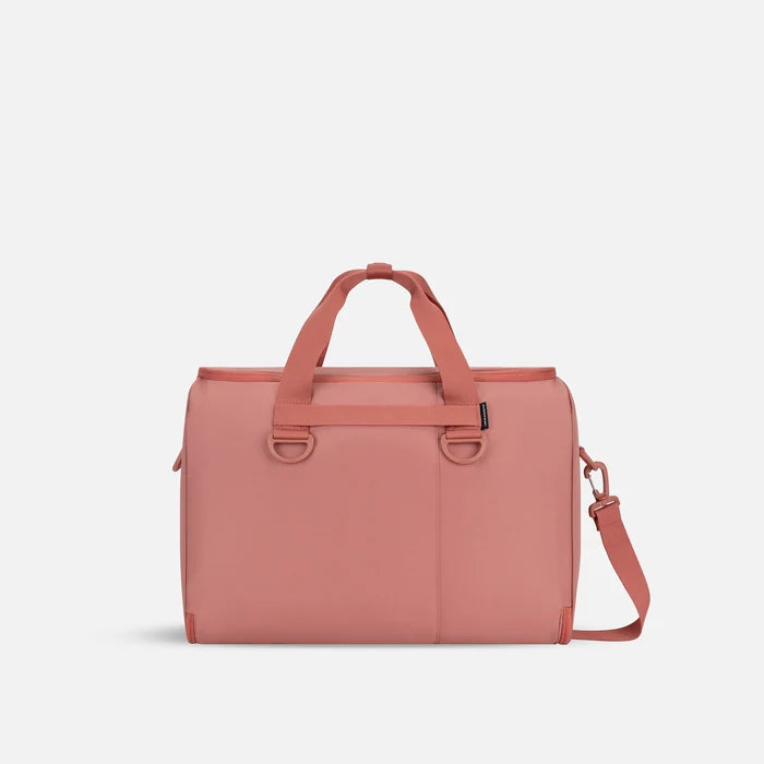 A Sherpani Jaunt Desert Pink Garment Duffle, back view showing straps & luggage strap on white backdrop.     #color_desert-pink