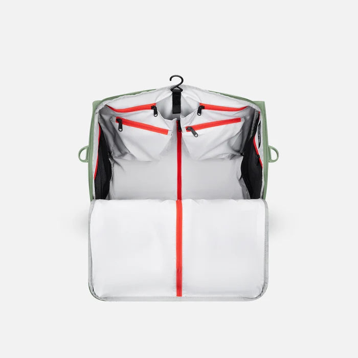 A Sherpani Jaunt Olivine Garment Duffle, back view showing straps & luggage strap on white backdrop.     #color_olivine-green