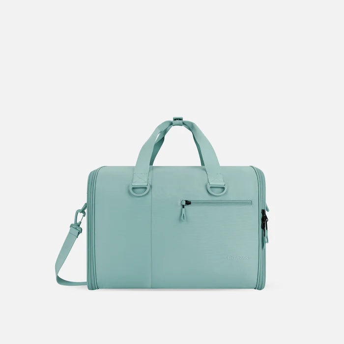 A Sherpani Jaunt Surf Blue Garment Duffle, front view showing straps & lockable pocket on white backdrop.   #color_surf-blue