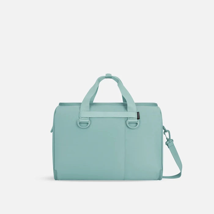 A Sherpani Jaunt Surf Blue Garment Duffle, back view showing straps & luggage strap on white backdrop.    #color_surf-blue