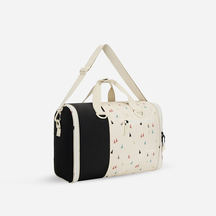 A Sherpani Jaunt Terrazzo Print Garment Duffle, 3/4 view showing two strap options on white backdrop.   #color_terrazzo-print