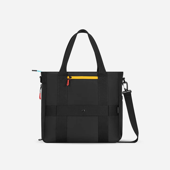A Sherpani Jetsetter Chromatic Black Travel Tote Bag, back view showing luggage strap and RFID pocket on white backdrop.   #color_chromatic-black