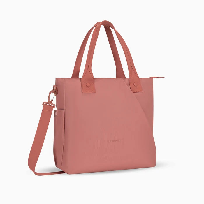 A Sherpani Jetsetter Desert Pink Travel Tote Bag, 3/4 view showing two strap options on white backdrop. #color_desert-pink