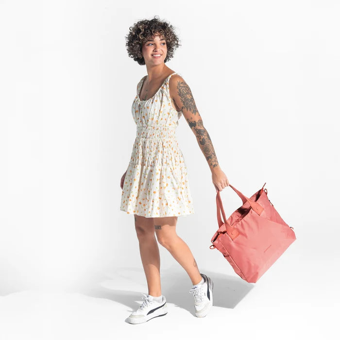 A woman holding a Sherpani Jetsetter Desert Pink Travel Tote Bag on white backdrop.  #color_desert-pink