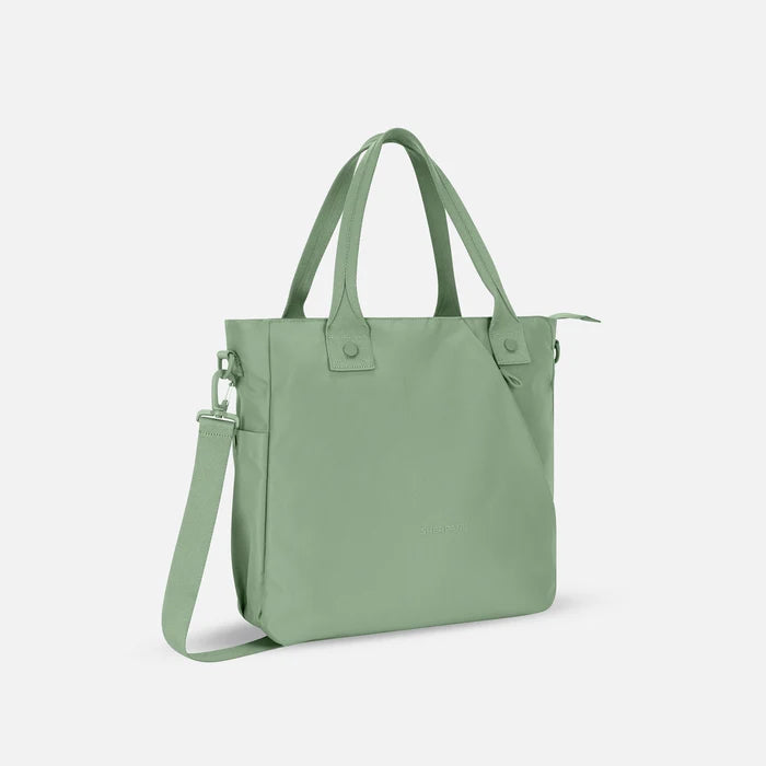 A Sherpani Jetsetter Olivine Travel Tote Bag, 3/4 view showing two strap options on white backdrop. #color_olivine-green