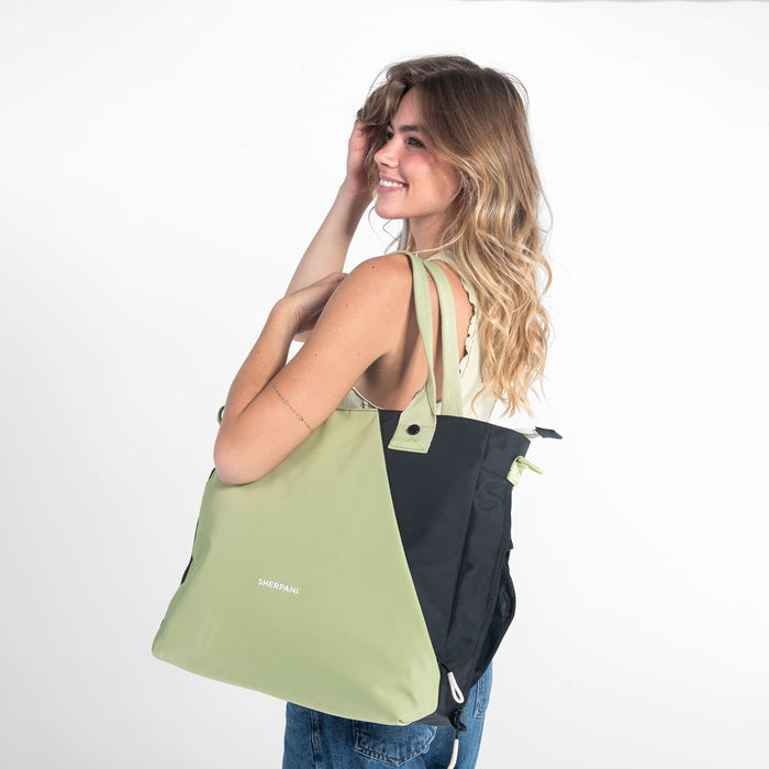 A woman wearing a Sherpani Jetsetter Palm Green Travel Tote Bag on white backdrop.  #color_palm-green