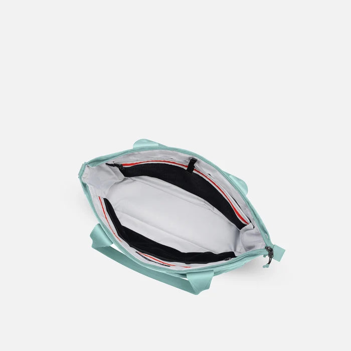 A Sherpani Jetsetter Surf Blue Travel Tote Bag, above view showing inside pockets on white backdrop. #color_surf-blue