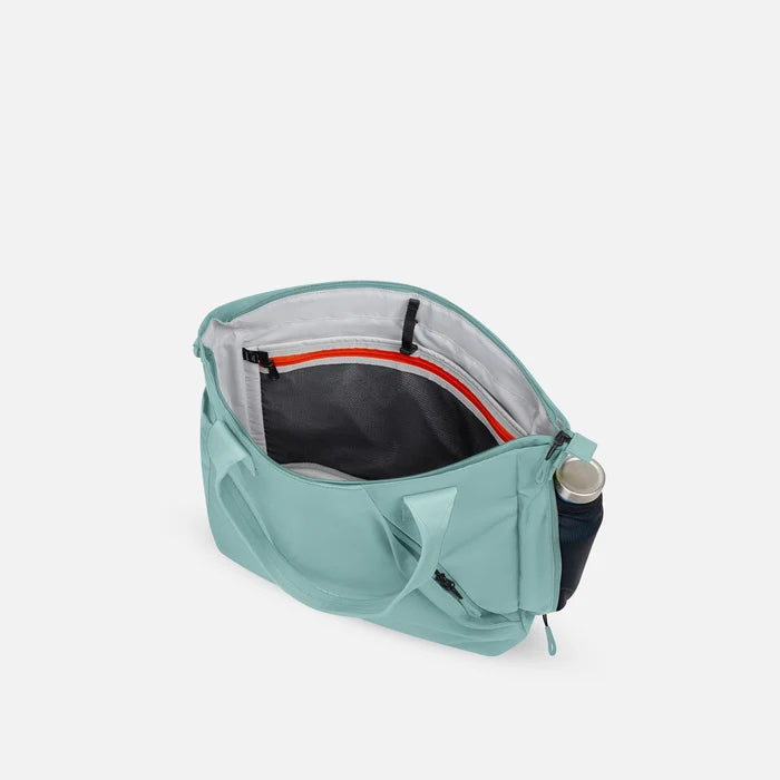 A Sherpani Jetsetter Surf Blue Travel Tote Bag, above view showing inside pockets on white backdrop. #color_surf-blue