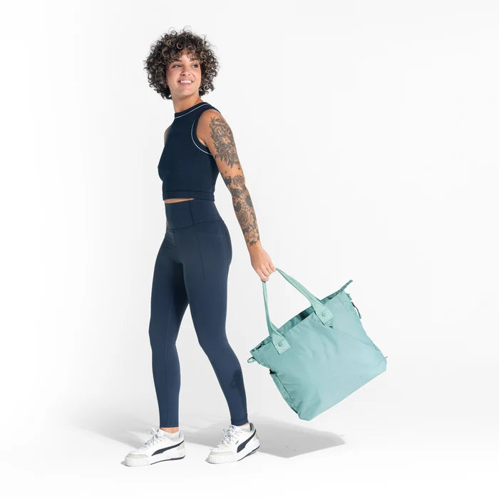 A woman holding a Sherpani Jetsetter Surf Blue Travel Tote Bag on white backdrop.  #color_surf-blue