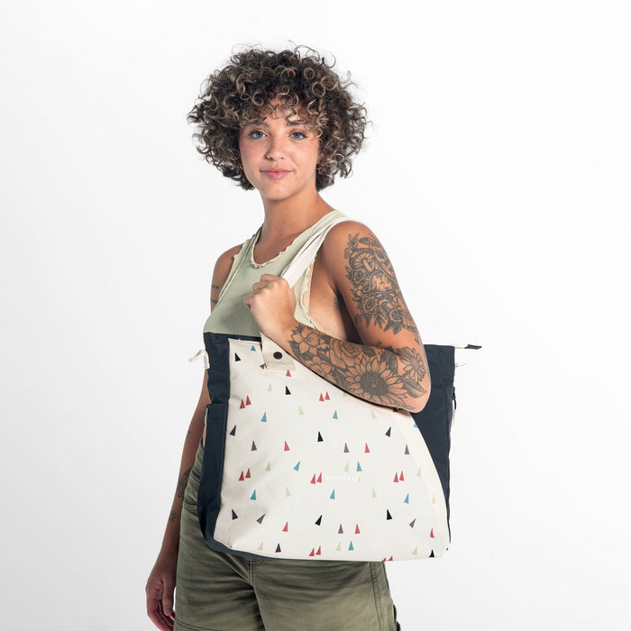 A woman wearing a Sherpani Jetsetter Terrazzo Print Travel Tote Bag on white backdrop. #color_terrazzo-print